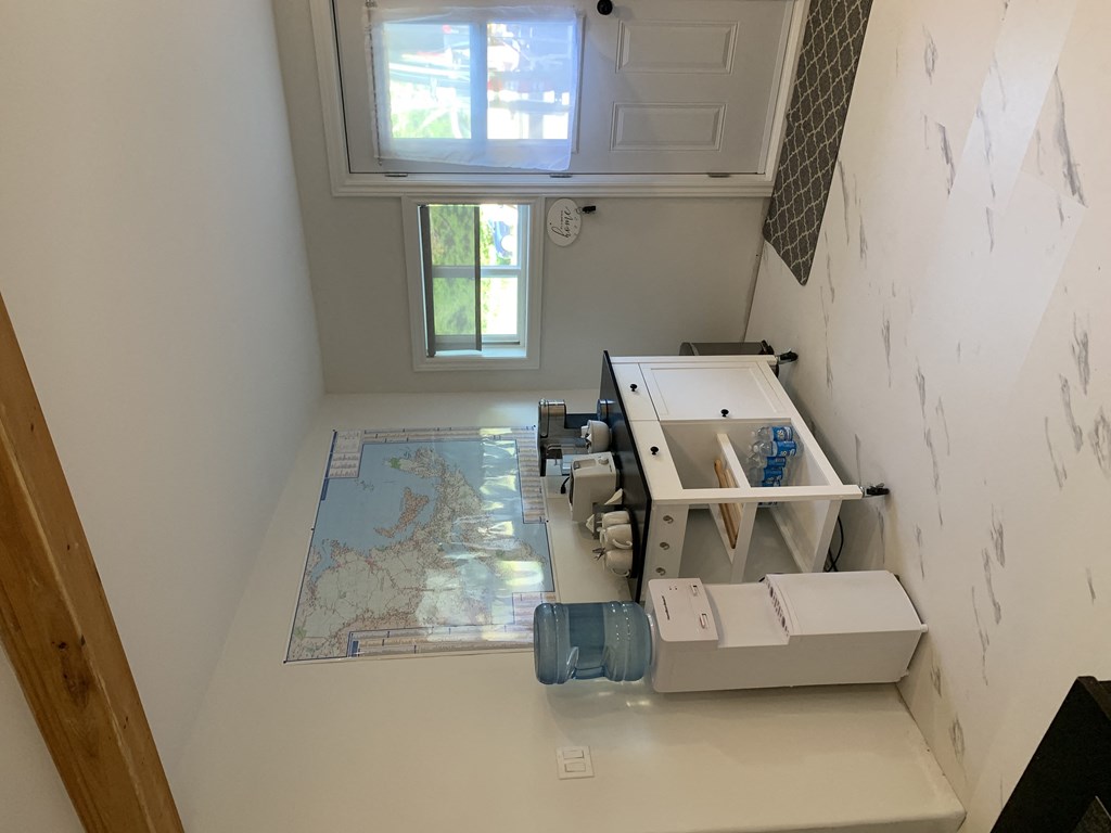 a model of a sewing machine on a table in a room with a window