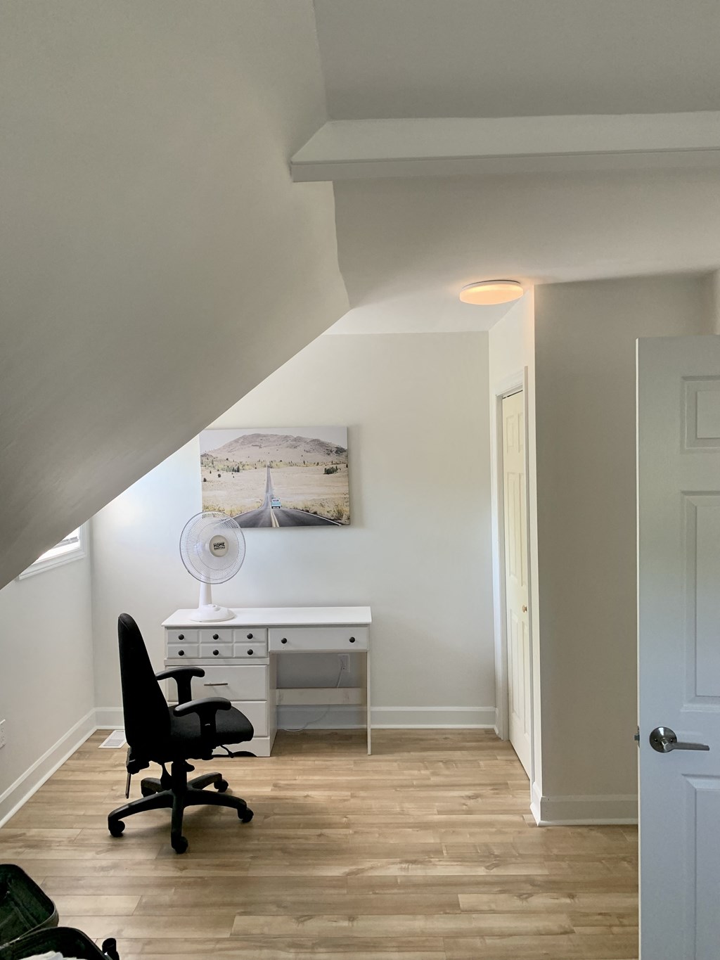 a home office with a desk and chair in a room with a staircase