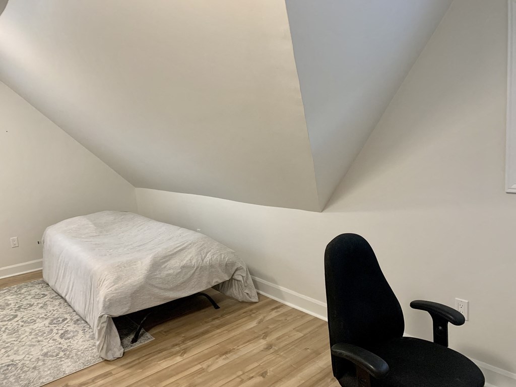 a small bedroom with a bed and a chair