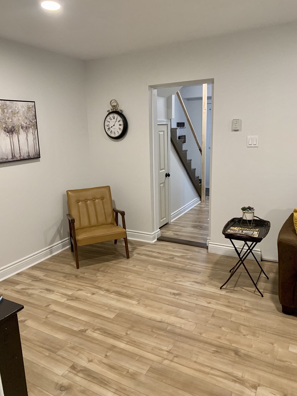 a living room with a chair and a clock on the wall