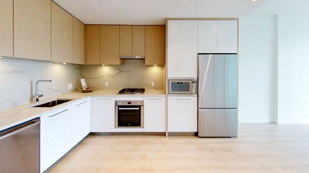 a kitchen with white cabinets and a stainless steel refrigerator