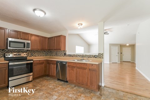 A kitchen with wooden cabinets and a tiled backsplash.
