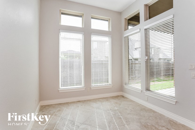 a living room with three windows and a tile floor