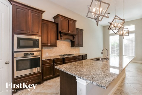 a kitchen with granite counter tops and wooden cabinets