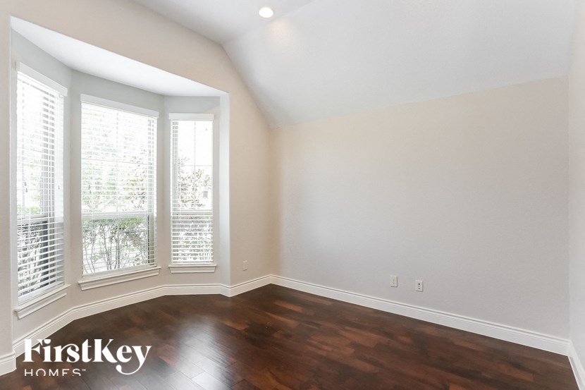 the living room with wood flooring and large windows