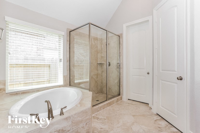 a bathroom with a tub and a shower and a window