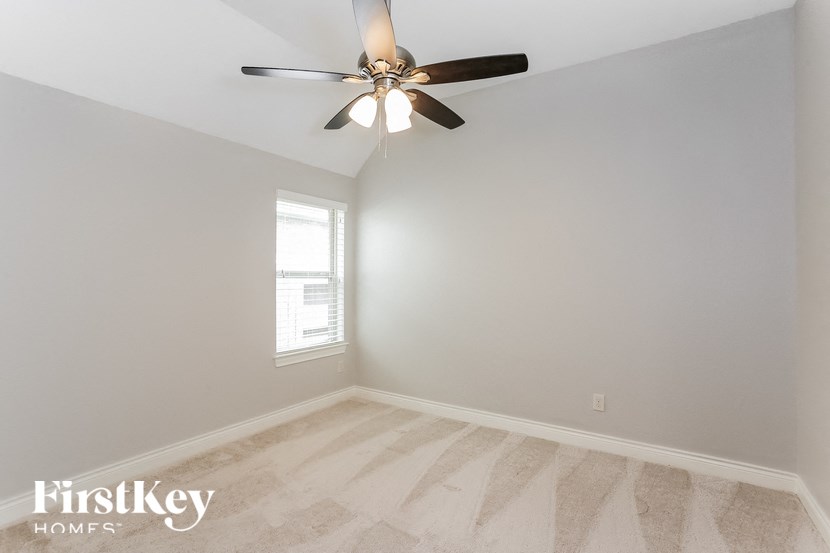 a bedroom with a ceiling fan and a window