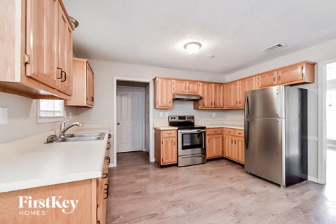 A kitchen with wooden cabinets and a stainless steel refrigerator.