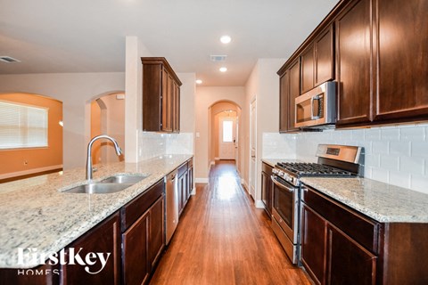 A kitchen with wooden cabinets and a granite countertop.