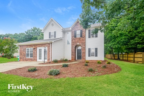 A house with a brick chimney and a white exterior is for sale by FirstKey Homes.