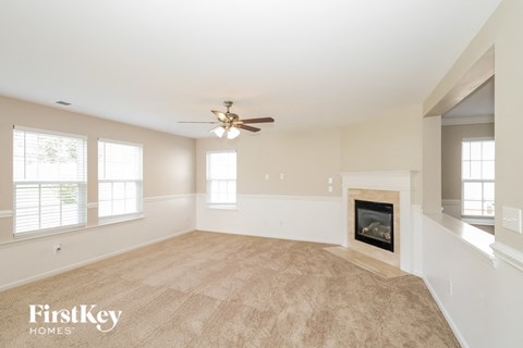 a living room with a fireplace and a ceiling fan