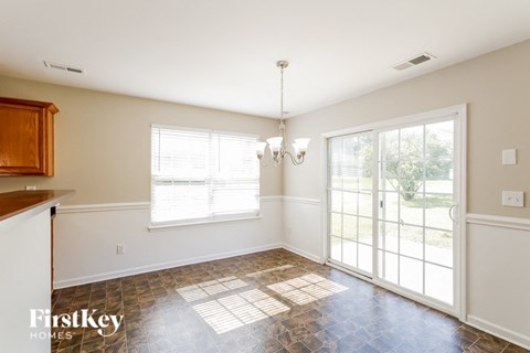 a dining room with a large window and a door to the backyard