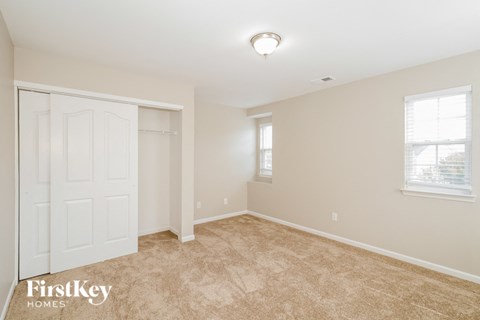 a bedroom with a white door and a carpeted floor
