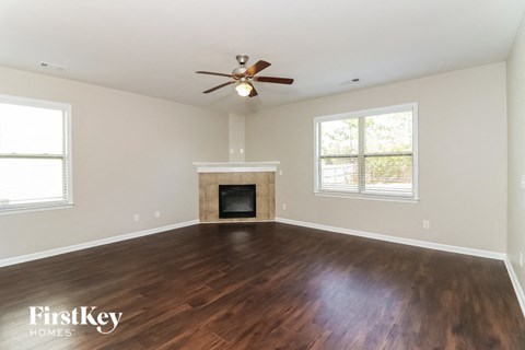 a living room with a fireplace and a ceiling fan