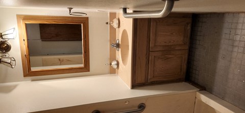 A bathroom with a mirror and a wooden door.