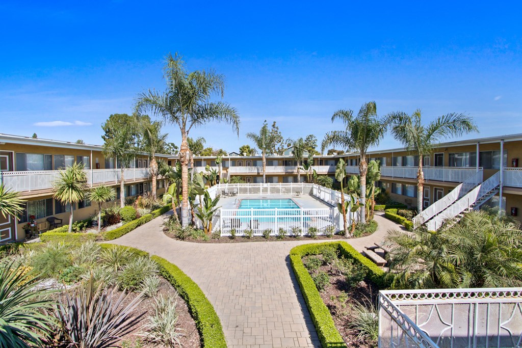 a building with a pool and palm trees