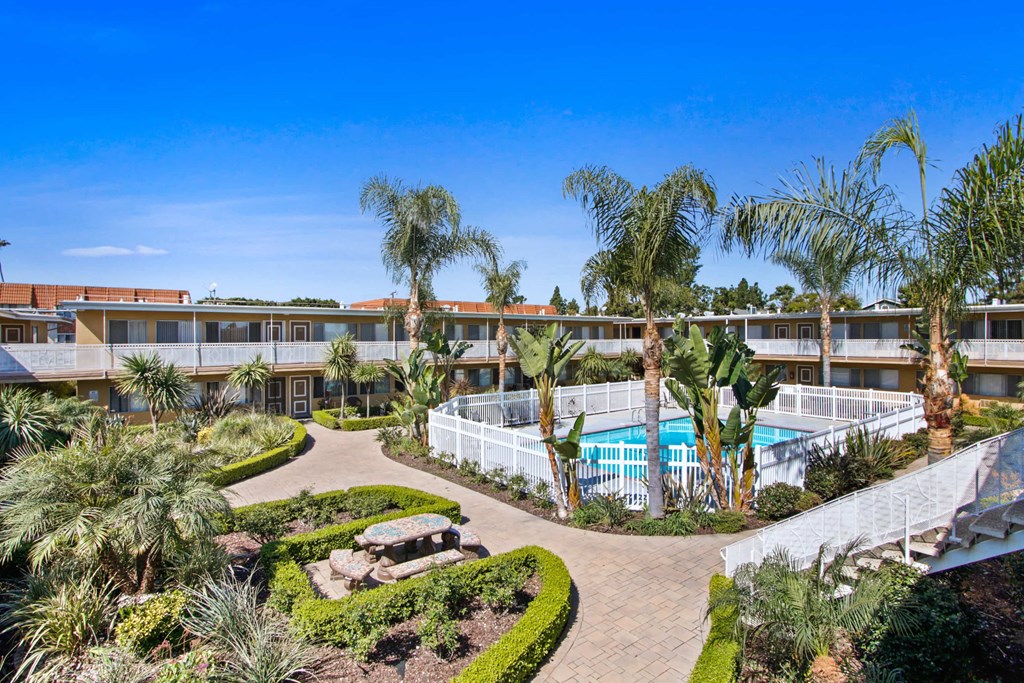 a building with a pool and palm trees in front of it