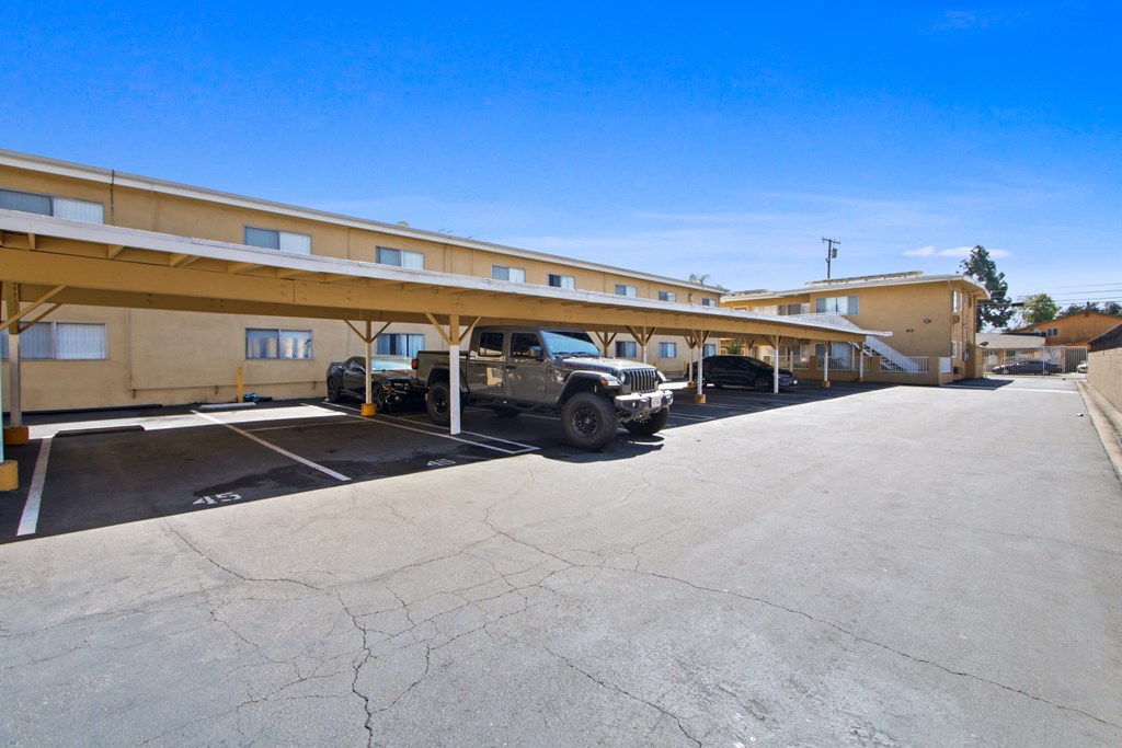 a parking lot with a truck parked in front of a hotel building