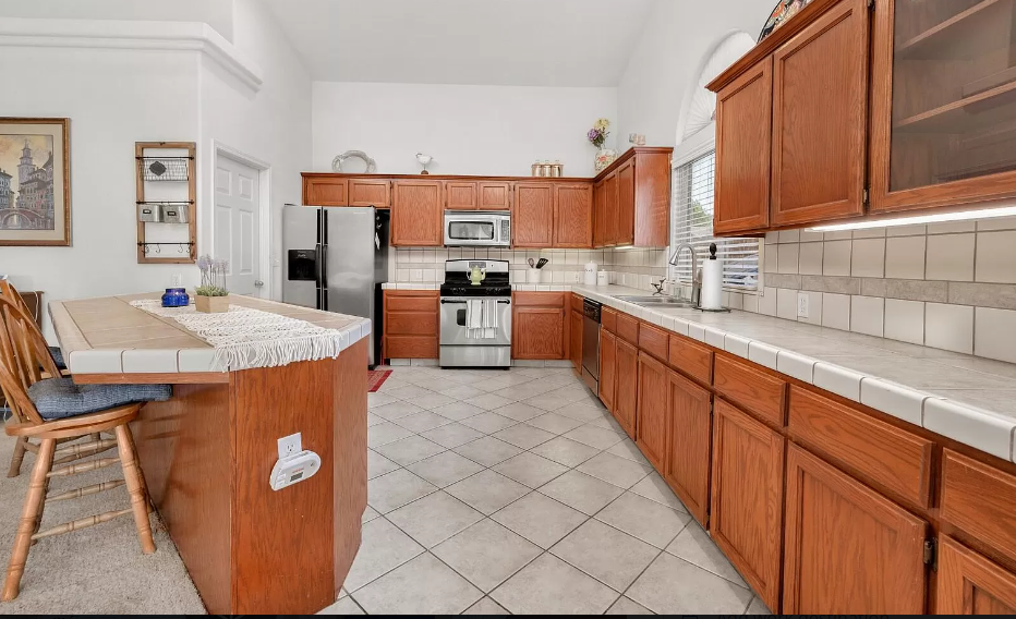 a large kitchen with wooden cabinets and stainless steel appliances