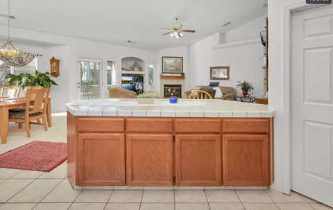 a kitchen with a counter top in the middle of a living room