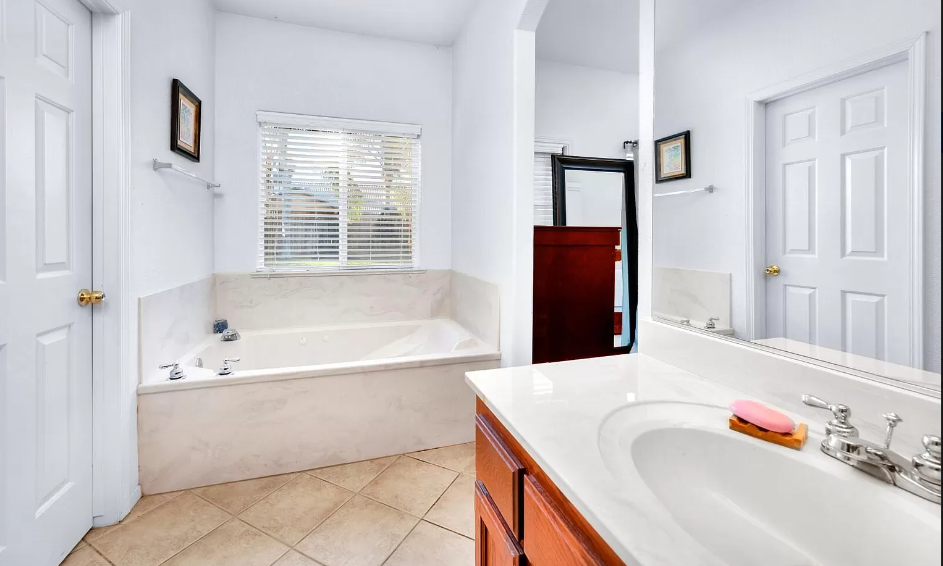 a bathroom with a tub and a sink and a mirror