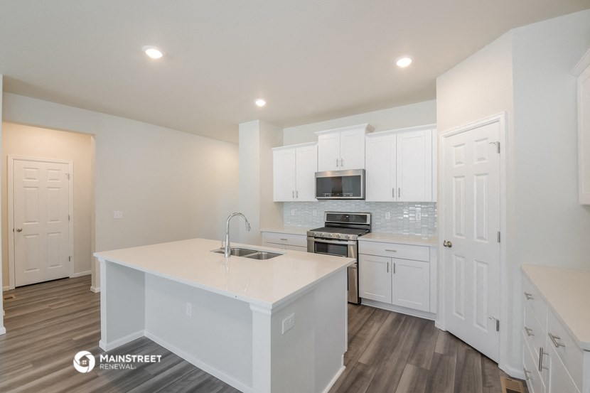 a kitchen with white cabinets and a white counter top