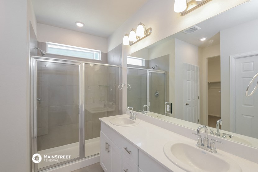 a white bathroom with two sinks and a shower