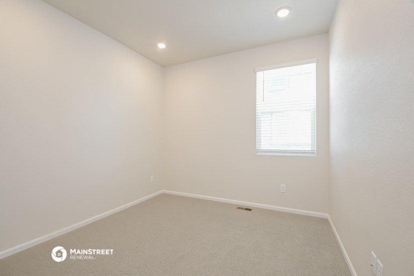 an empty room with white walls and a window