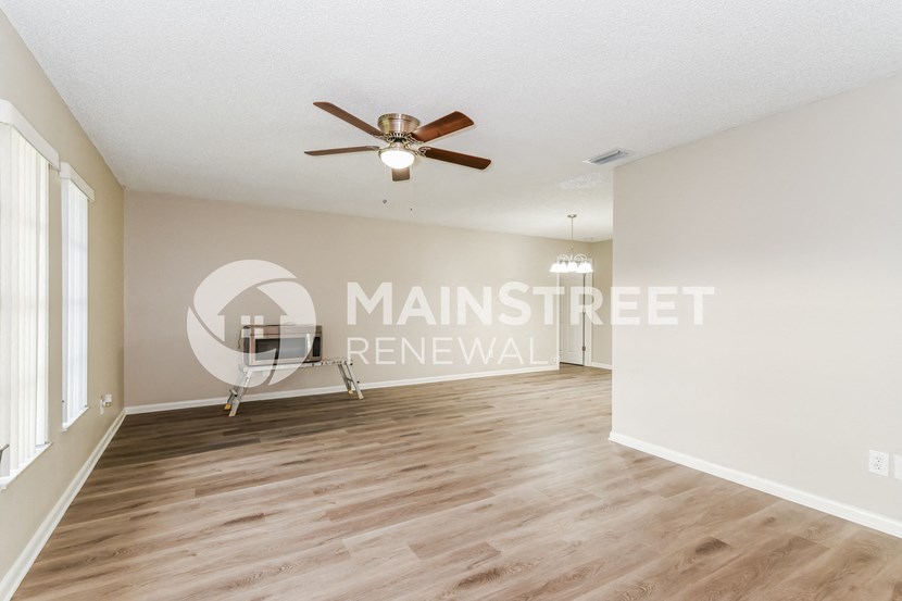a living room and dining room with hardwood floors and a ceiling fan