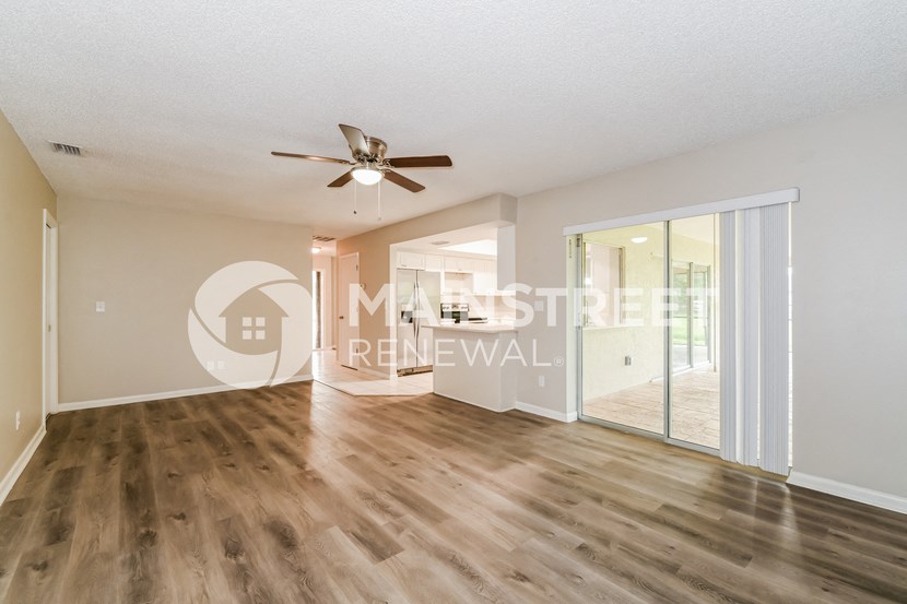 a living room with hard wood floors and a ceiling fan