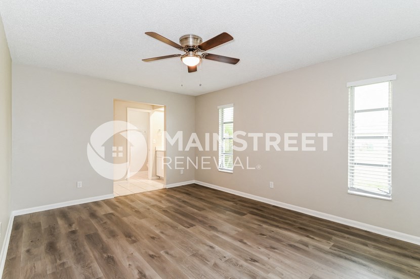 a living room with hardwood floors and a ceiling fan