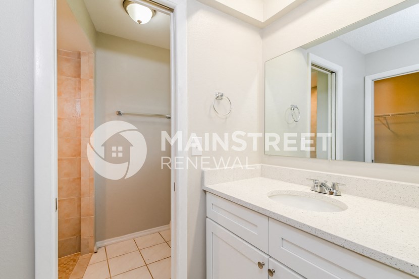 a white bathroom with a sink and a mirror
