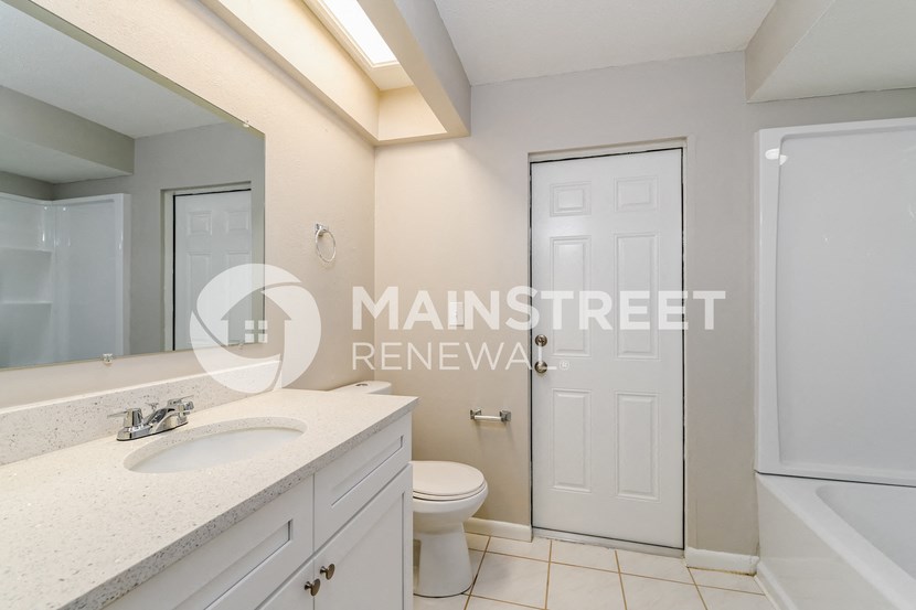 a white bathroom with a toilet and a sink