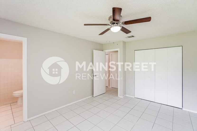 a renovated living room with a closet and a ceiling fan