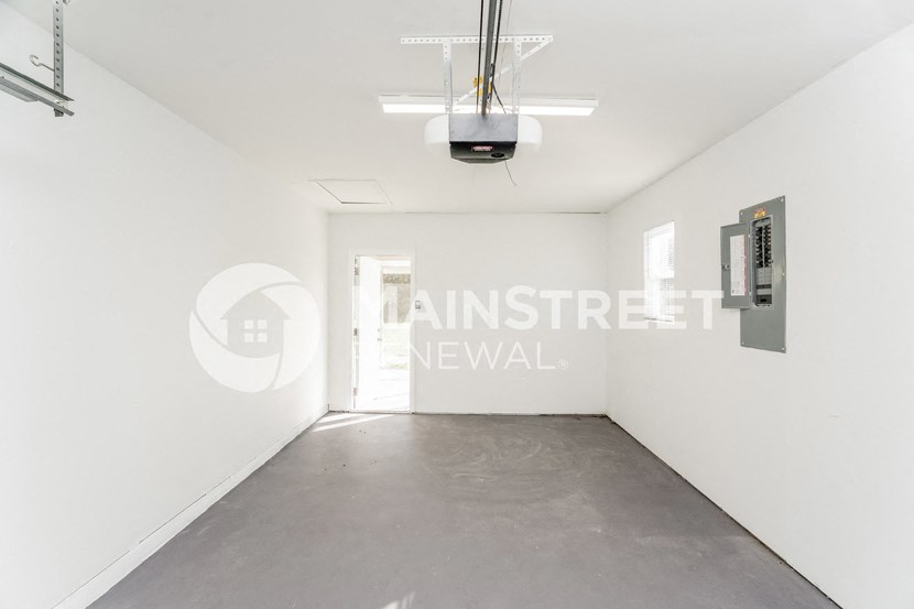 a room with a concrete floor and a white wall