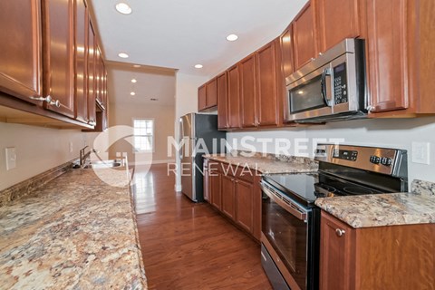 a kitchen with wood cabinets and granite counter tops and stainless steel appliances
