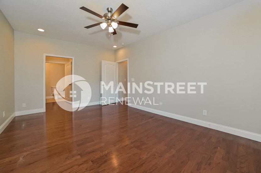 a living room with hardwood floors and a ceiling fan