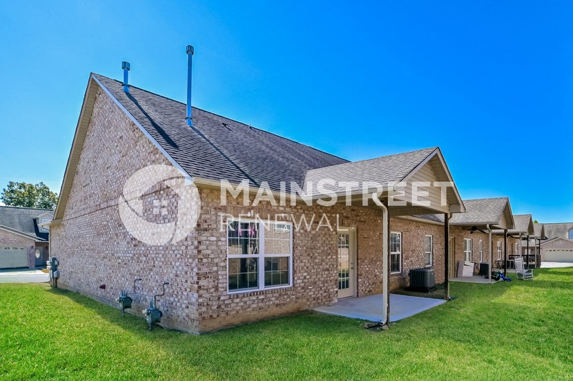 a small brick building with a lawn outside of it