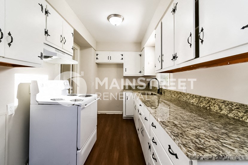 a white kitchen with marble counter tops and white cabinets