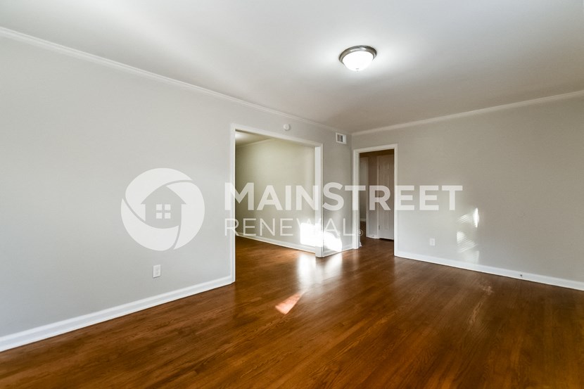 a bedroom apartment with hardwood floors and white walls