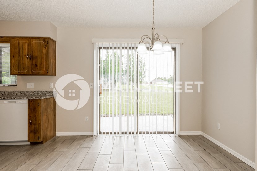 a kitchen and living room with a sliding glass door