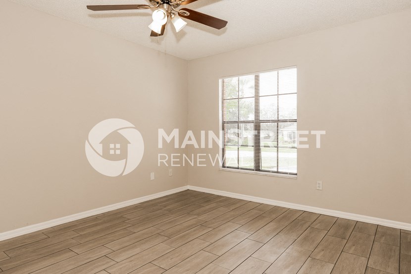 a living room with a ceiling fan and a window