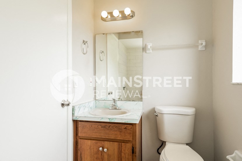 a bathroom with a toilet and a sink and a mirror