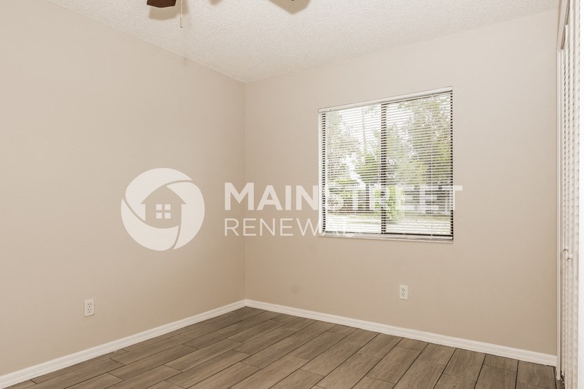 a living room with a window and a wooden floor
