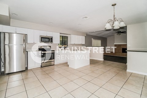 a renovated kitchen with white cabinets and stainless steel appliances