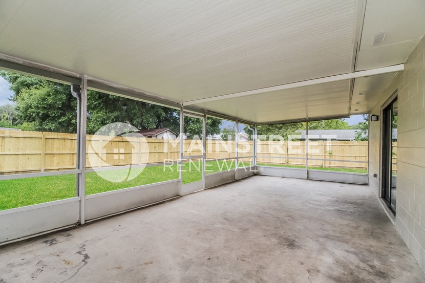a patio on the back of a house with a fenced in yard