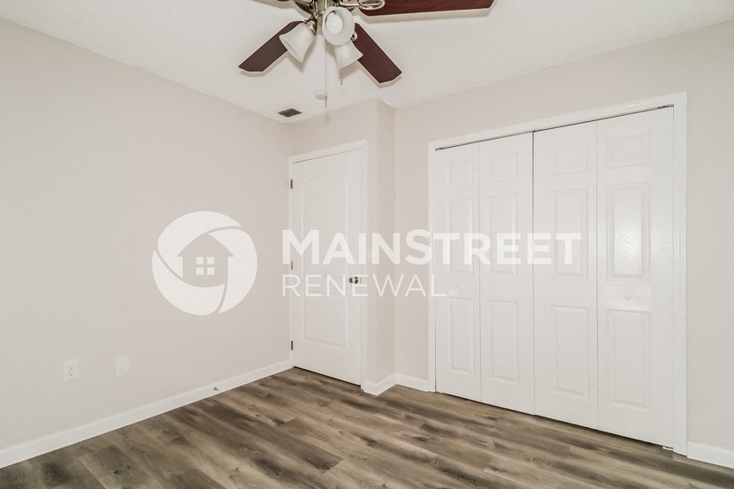 a bedroom with two closets and a ceiling fan