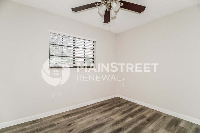 a bedroom with a ceiling fan and a window