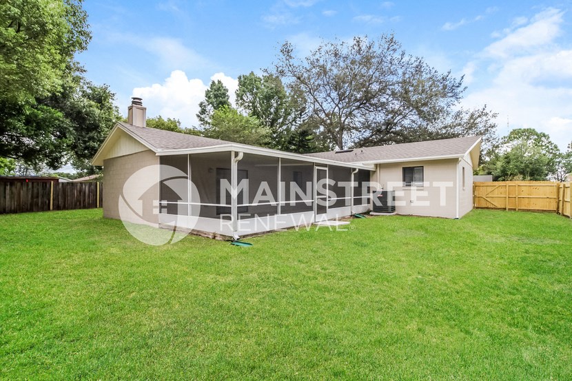 a small house with a yard and a fence