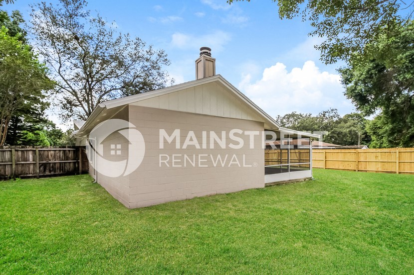 a detached garage with a fenced yard and grass